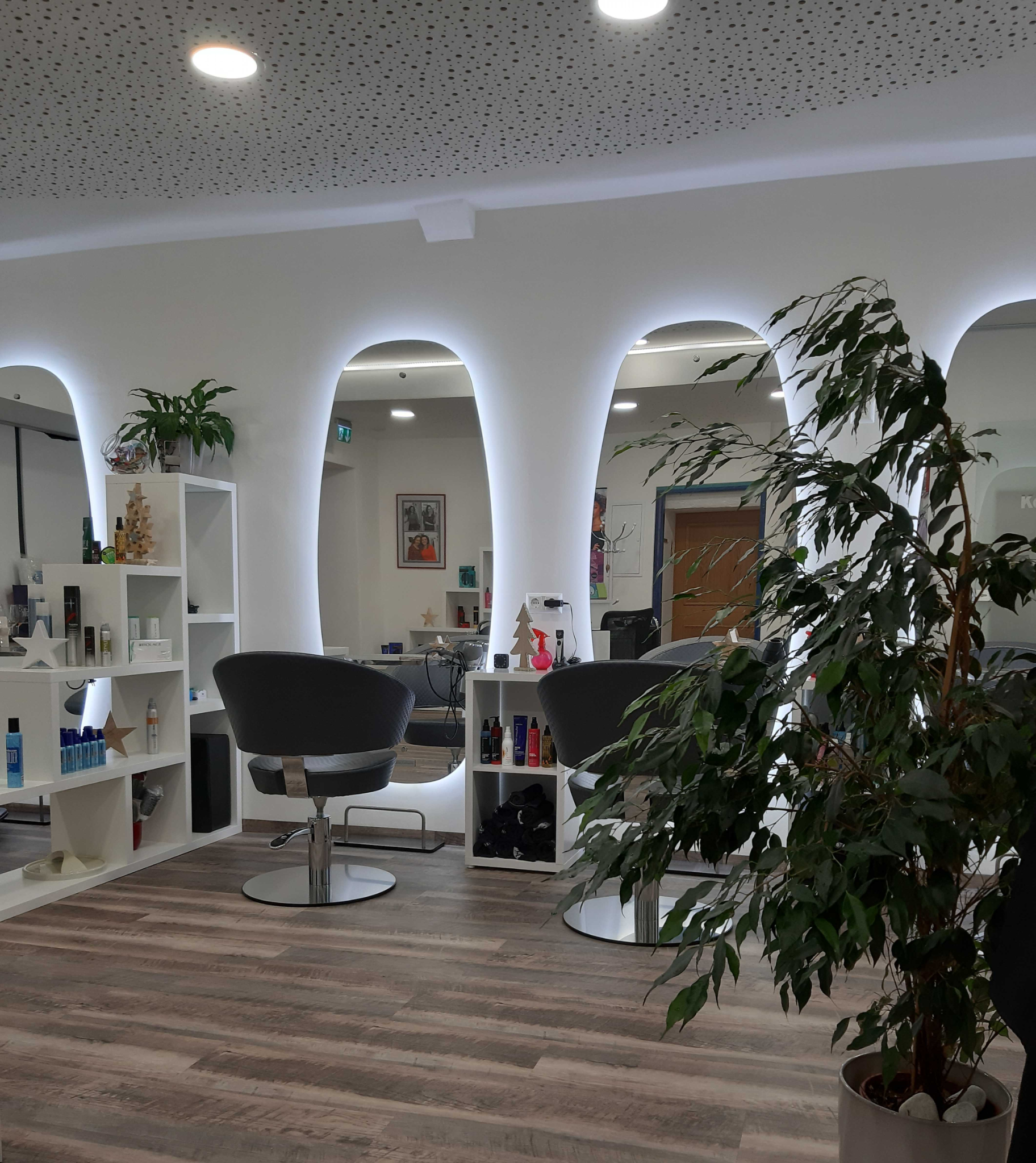 Heller, modern renovierter Marktfriseur-Salon mit beleuchteten Spiegeln und Bedienplätzen